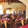 Un ristorante con tavoli apparecchiati e sedie disposte in file.