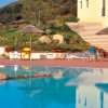Piscina riflettente con ombrelloni e sedie a bordo.