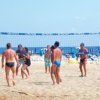 Persone giocano a beach volley sulla spiaggia.