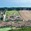 Complesso residenziale vicino al mare e campi verdi.