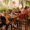 Ristorante all'aperto affollato con tavoli e persone che mangiano.