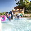 Bambini giocano con ciambelle in piscina.