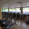 Una palestra con attrezzi da fitness e una persona su un tapis roulant.