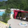 Area piscina e palco all'aperto con colline sullo sfondo.