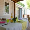 Veranda con tavolo apparecchiato e bottiglia di vino.