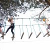 Bambini su un ponte di corda tra gli alberi.