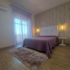 Camera da letto con letto viola e tende trasparenti, luce calda.