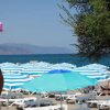 Spiaggia con ombrelloni a righe bianche e azzurre.