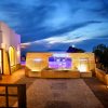 Spazio esterno serale con fontana illuminata e vista sul cielo blu scuro.