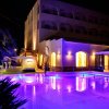 Edificio illuminato di notte con piscina e luci viola.