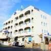 Edificio bianco con balconi, insegna dell'hotel e bandiera italiana.