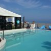 Una piscina con gazebo decorato con palloncini azzurri, vista mare.