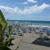 Una spiaggia attrezzata con lettini e ombrelloni blu su sabbia, vista sul mare.