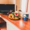 Scrivania con fiori, cocktail e TV.