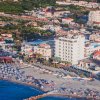 Veduta aerea di una spiaggia affollata e città.