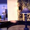 Tavolo con lampada e pianta vicino a muro di pietra.