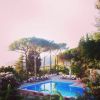 Piscina all'aperto circondata da alberi e sedie a sdraio.