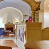 Reception con arco in pietra e poltrone.