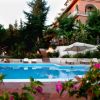Piscina con verde e fiori intorno.