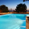 Piscina illuminata al tramonto con alberi intorno.