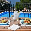 Tavolo con piatti di cibo e vino vicino a piscina.