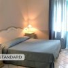Camera da letto standard con letto matrimoniale e lampade sui comodini.