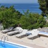 Lettini vicino alla piscina con vista mare.