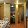 Interno di un bungalow con tavolo, sedie e cucina.