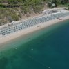 Spiaggia con file di ombrelloni e acqua cristallina.