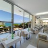 Ristorante con vetrate vista mare e tavoli apparecchiati.