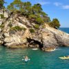 Scogliera costiera con persone in kayak e paddle board.
