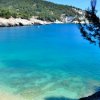 Baia con acqua turchese e alberi sulla riva.