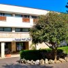 Ingresso di un hotel con alberi e piante.
