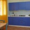 Cucina moderna con mobilio blu e tavolo da pranzo.