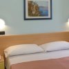 Letto matrimoniale con luci soffuse e quadri alle pareti.
