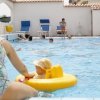 Piscina con bagnanti e giochi in acqua.