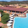 Complesso alberghiero con ampia piscina a forma libera e ombrelloni bianchi.