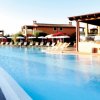 Una grande piscina all'aperto con sedie a sdraio e ombrelloni bianchi.