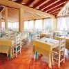 Ristorante con tavoli apparecchiati e ampie finestre.