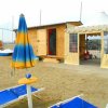Ombrelloni blu e gialli vicino a un capanno sulla spiaggia.