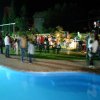 Festa notturna accanto a una piscina illuminata.