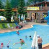 Piscina all'aperto con scivoli e ombrelloni.