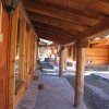 Corridoio esterno di chalet in legno, con pietre sul pavimento.
