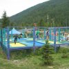 Area recintata per trampolini con persone che saltano.