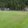 Un campo da calcio con due porte, circondato da alberi.