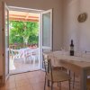 Cucina con tavolo apparecchiato vista su terrazza.