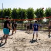Partita di beach volley con diversi giocatori.