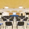 Sala conferenze con sedie blu e schermo davanti.