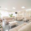 Lounge con divani beige e piante.