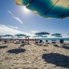 Spiaggia con ombrelloni blu sotto il sole.